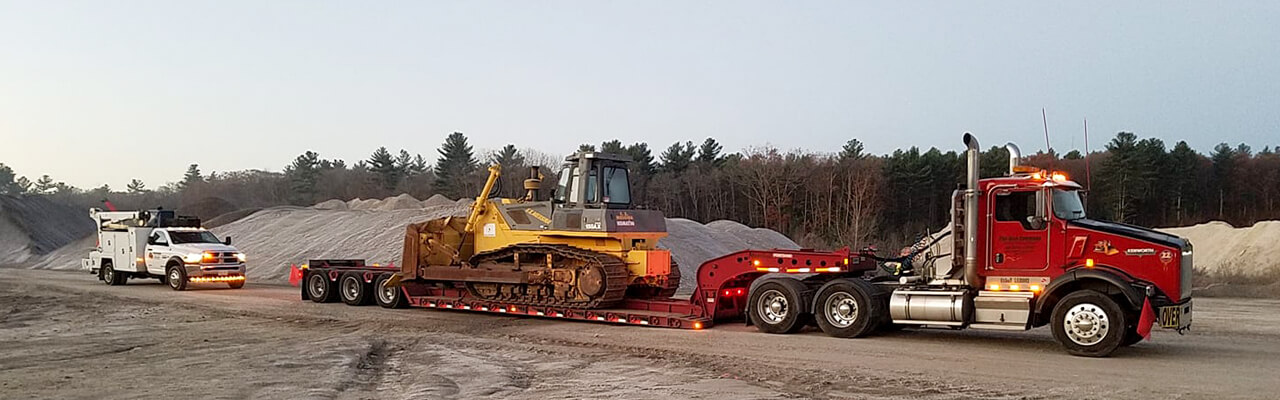 Semi with lowboy trailer hauling a crawler dozer